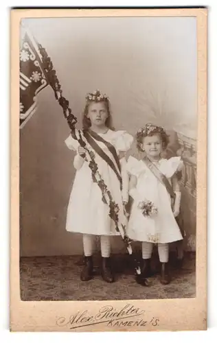 Fotografie Alex Richter, Kamenz, zwei niedliche Mädchen in weissen Kleidern mit geschmückter Flagge und Blumen im Haar
