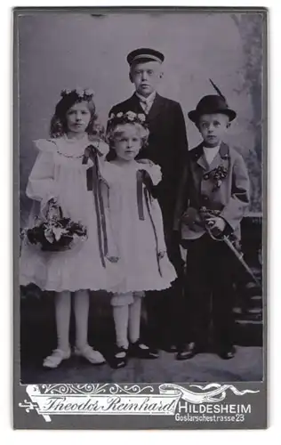 Fotografie Theodor Reinhard, Hildesheim, niedliche Kinder in weissen Kleidern und im Anzug mit Blumen im Haar und Säbel