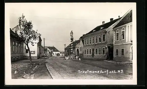 AK Trautmannsdorf a. d. L., Strassenpartie mit Denkmal