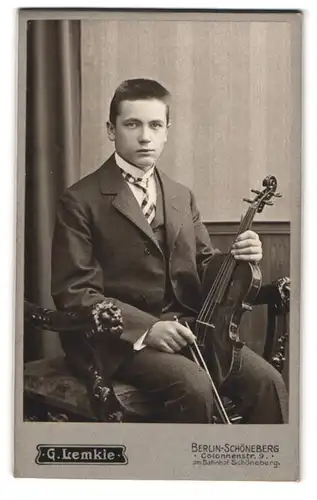 Fotografie G. Lemkie, Berlin-Schöneberg, Portrait junger Mann im karierten Anzug mit Geige / Violine im Atelier