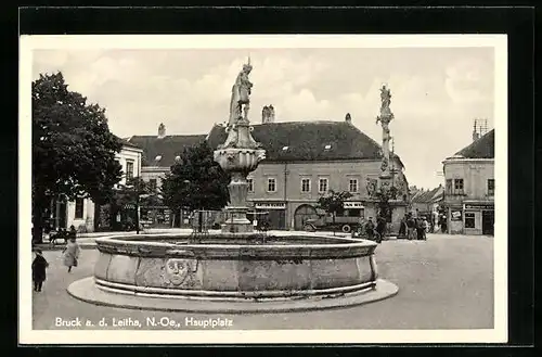 AK Bruck a. d. Leitha, Hauptplatz mit Geschäften und Brunnen