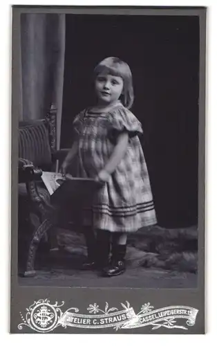 Fotografie Atelier C.Strauss, Cassel, Leipzigerstrasse 15, süsses kleines Mädchen posiert in kariertem Kleidchen