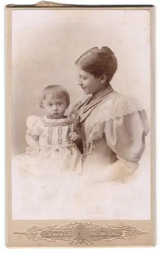 Fotografie O.Ewald, Bromberg, elegante junge Frau mit Hochsteckfrisur und kleinem Mädchen auf dem Schoss