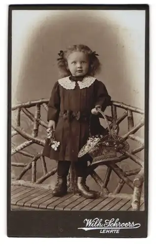 Fotografie Wilh. Schroers, Lehrte, Kleines Mädchen im Kleid mit Blumenkorb