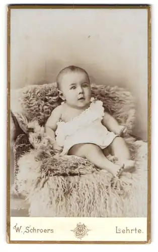 Fotografie W. Schroers, Lehrte, Sedanstrasse 9, Kleinkind mit weissem Kleidchen im Pelz sitzend