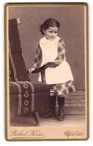 Fotografie Robert Kurz, Stuttgart, Mädchen im karierten Kleid neben Sessel