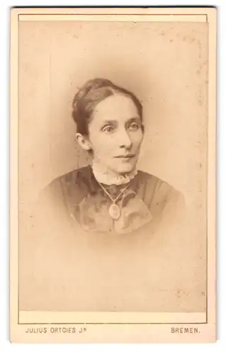 Fotografie Julius Ortgies Jr., Bremen, Am Wall 116, Zierliche Dame mit Hochsteckfrisur mit Medaillonhalskette
