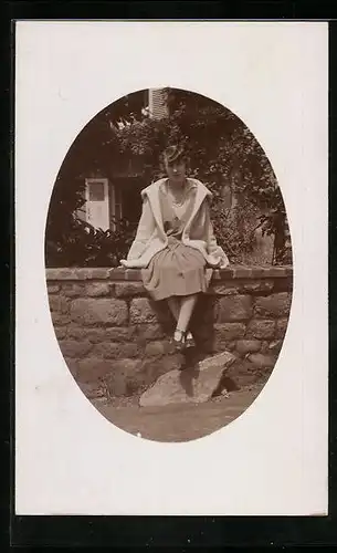 AK Bagnoles-de-l`Orne, Junge Frau sitzt auf einer Mauer