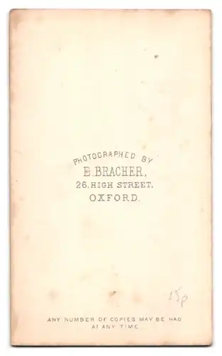 Fotografie E. Bracher, Oxford, älterer englischer Herr im Anzug mit Fliege und Buch in der Hand