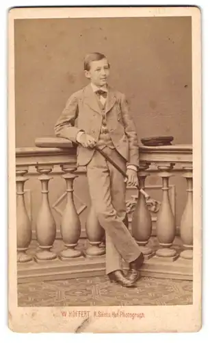 Fotografie W. Höffert, Dresden, Portrait junger Knabe im hellen Anzug kokettiert mit Flanierstock im Atelier
