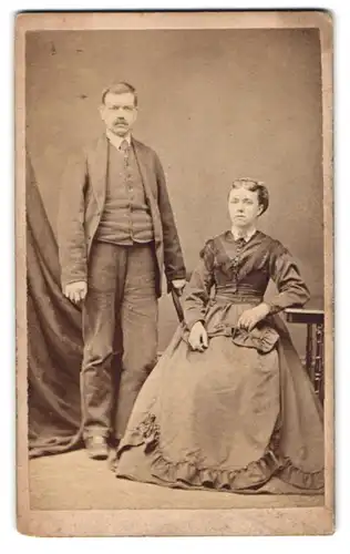 Fotografie T. Robinson, Thornton, englisches Paar im Tweedanzug und im dunklen Kleid mit Fransen