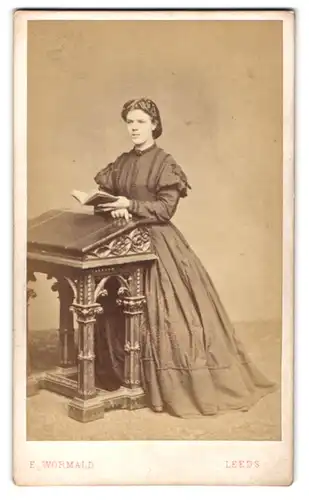 Fotografie E. Wormald, Leeds, englische Dame im dunklen Kleid mit Buch am Lesepult