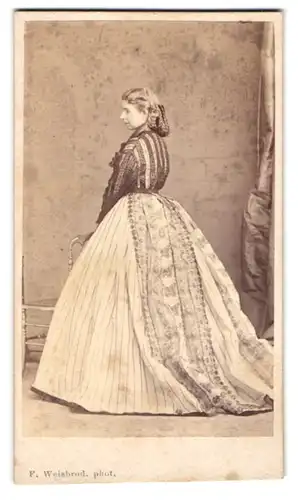 Fotografie F. Weisbrod, Frankfurt / Main, junge Frau im gestreiften Kleid mit geflochtenen Haaren, Rückenportrait