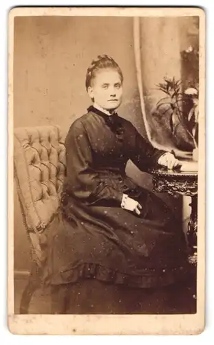 Fotografie C. Wolff, Neu-Strelitz, Schloss-Strasse 14, Dame im Tournürenkleid mit geflochtenen Haaren