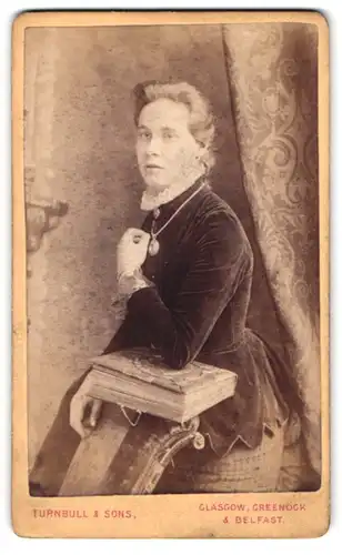 Fotografie Turnbull & Sons, Belfast, 23 Garfield St., Portrait blonde Dame mit Halskette und Brosche am Rüschenkragen