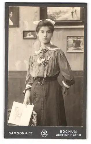 Fotografie Samson & Co., Bochum, Wilhelmsplatz 8, Portrait bildschönes Fräulein mit Haarschleife und Buch in der Hand