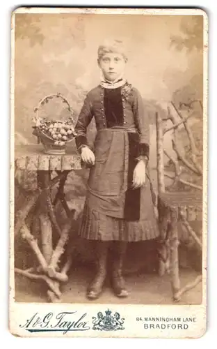 Fotografie A. & G. Taylor, Bradford, 84 Manningham Lane, Portrait blondes Mädchen mit Obstkorb