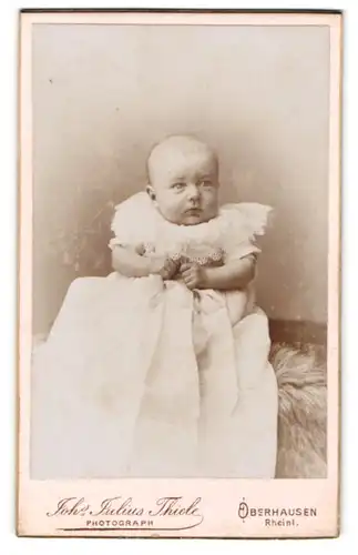 Fotografie Joh. Julius Thiele, Oberhausen / Rheinland, Friedrich-Carl-Strasse 32, Portrait Baby im Taufkleidchen
