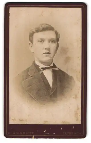 Fotografie W. Grigolet, Rathenow, Portrait charmanter junger Mann mit Fliege im Jackett