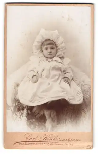 Fotografie Carl Köhler, Berlin-Schöneberg, Colonnen-Strasse 35, Kleines Kind im Kleid sitzt auf Fell