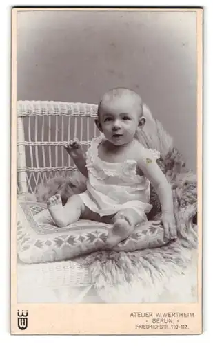 Fotografie W. Wertheim, Berlin, Friedrichstrasse 110-112, Süsses Kleinkind im Hemd sitzt auf Kissen