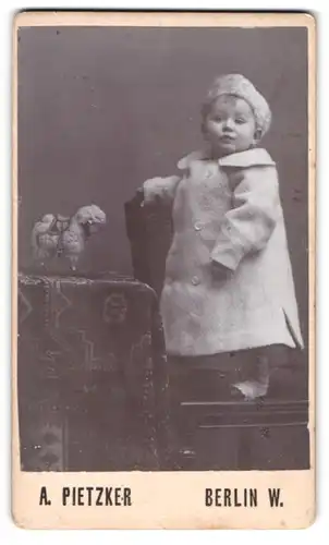 Fotografie A. Pietzker, Berlin, Potsdamerstr. 116 a, Kleinkind im Mantel Spielzeug-Schaf