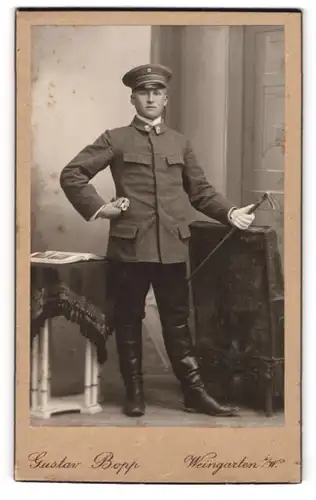Fotografie Gustav Bopp, Weingarten i. W., junger Beamter in Dienstuniform mit Stock und Schirmmütze