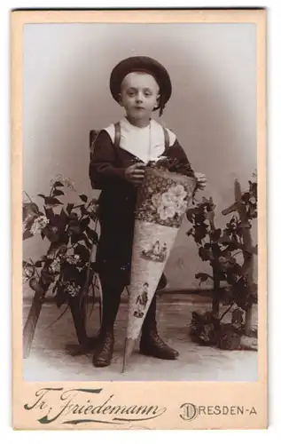 Fotografie Tr. Friedemann, Dresden, Portrait junger Knabe mit grosser Zuckertüte und Schulranzen, erster Schultag