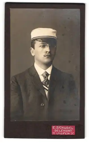 Fotografie E. Schudel, Delemont, junger Student im Anzug mit Couleur und Biedermeiermütze, Zwicker Brille