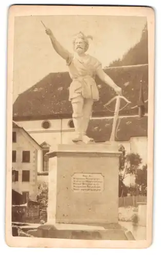 Fotografie Fotograf unbekannt, Portrait Altdorf / Uri, Blick auf das alte Tell Denkmal aus Gips vor der Kirche