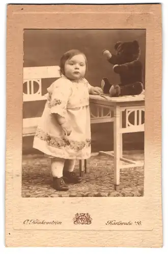Fotografie O. Klinkowström, Karlsruhe, kleines Mädchen Ida Alwine Unmack im Kleidchen mit Teddybär auf dem Tisch