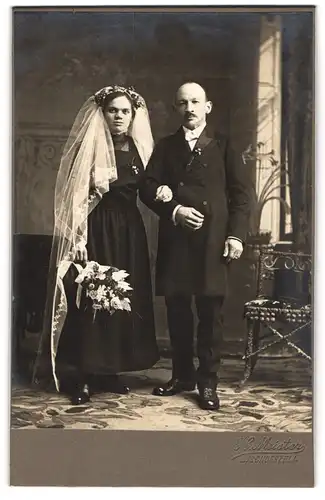 Fotografie H. Meister, Bischofszell, Eheleute im schwarzen Brautkleid und im Anzug mit Brautstrauss