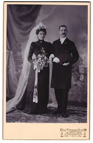 Fotografie J. Dentel, Strassburg i. Els., Eheleute im schwarzen Hochzeitskleid und im Anzug mit Zylinder