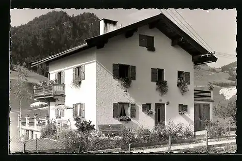 Foto-AK Kössen am Kaisergebirge, Personen schauen aus dem Haus Gurtner
