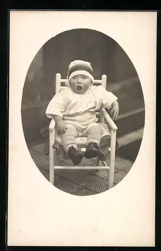 Foto-AK Kleinkind mit Schnuller auf dem Stuhl
