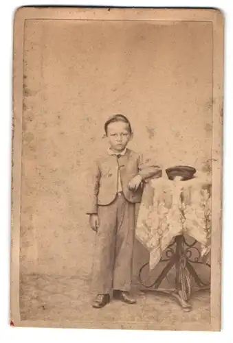 Fotografie unbekannter Fotograf und Ort, kleiner Junge stützt sich auf einen Tisch