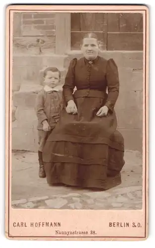 Fotografie Carl Hoffmann, Berlin, Naunynstr. 38, Portrait stolzer Mutter im Kleid mit frechem Buben im Anzug