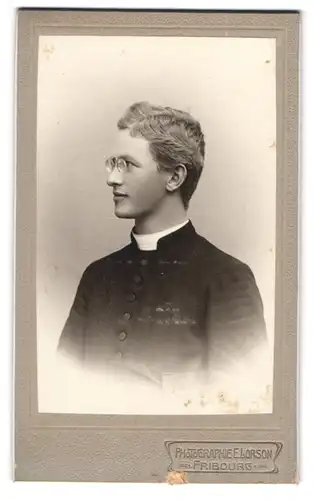 Fotografie E. Lorson, Fribourg, junger Pastor im Talar mit Zwickerbrille