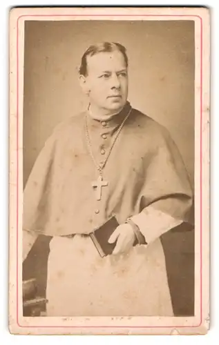 Fotografie unbekannter Fotograf und Ort, Portrait Pastor im hellen Talar mit Kruzifix und Bibel in der Hand