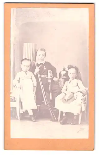 Fotografie Otto Johnsen, Döbeln, zwei kleine Mädchen mit Bruder in Uniform und Pickelhaube als Kadett