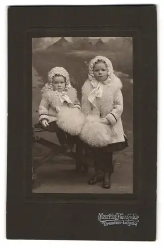 Fotografie MArtin Herzfeld, Dresden, zwei niedliche Mädchen in heller Winterkleidung mit Häubchen