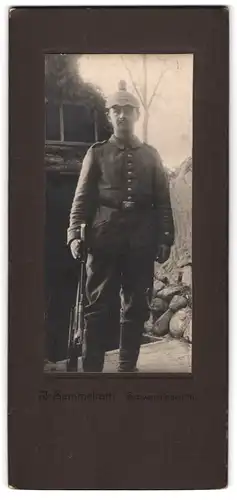 Fotografie J. Semmelroth, Schwenningen, junger Artillerist in Feldgrau Uniform mit Picklehaube Tarnbezug und Karabiner