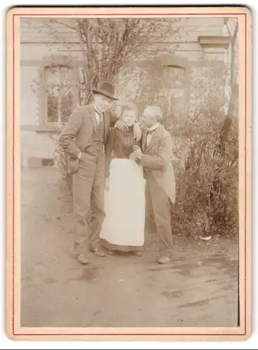 Fotografie unbekannter Fotograf und Ort, zwei Herren umwerben eine junge Frau mit Schürze