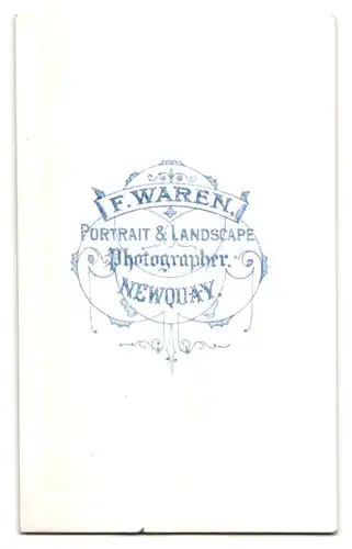 Fotografie F. Waren, Newquay, Goldiges Kleinkind mit krausen Löckchen und Korbgeflecht