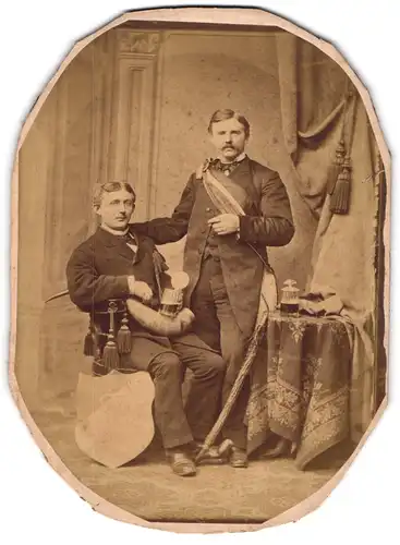 Fotografie unbekannter Fotograf und Ort, zwei Studenten in Anzügen mit Wappenschild und langer Pfeife, Couleur