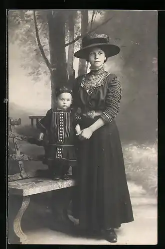 Foto-AK Mutter mit Strohut neben ihrem Kind in Studiokulisse