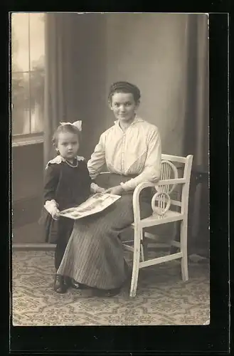 Foto-AK Mutter und Tochter lesen ein Buch in Studiokulisse