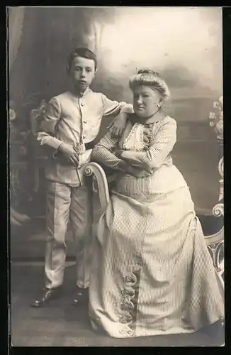 Foto-AK Mutter im langen Kleid neben ihrem Sohn in Studiokulisse