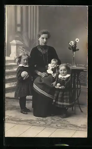 Foto-AK Mutter mit ihren Kindern mit Spielzeug in Studiokulisse