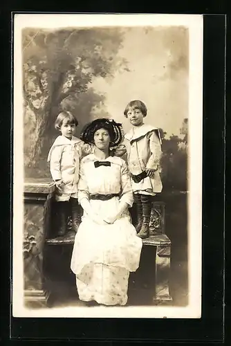 Foto-AK Mutter neben ihren Kindern in Studiokulisse